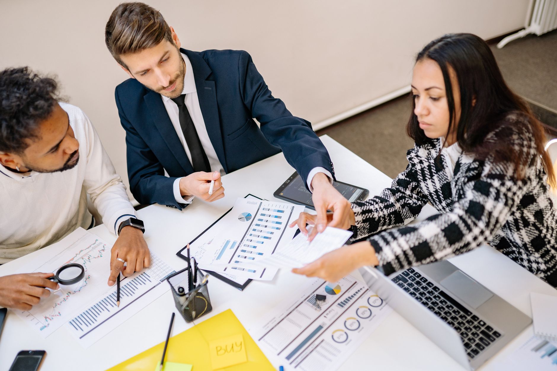 Business professionals engaging in a collaborative meeting with charts and documents. — "Express Your Emotions Without Judgme