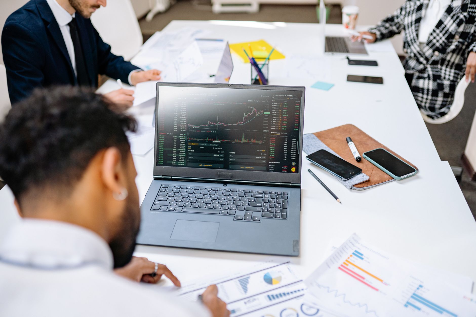 Team collaborating in an office setting, discussing financial graphs on a laptop screen. — High-Performance Urethane Mixers f