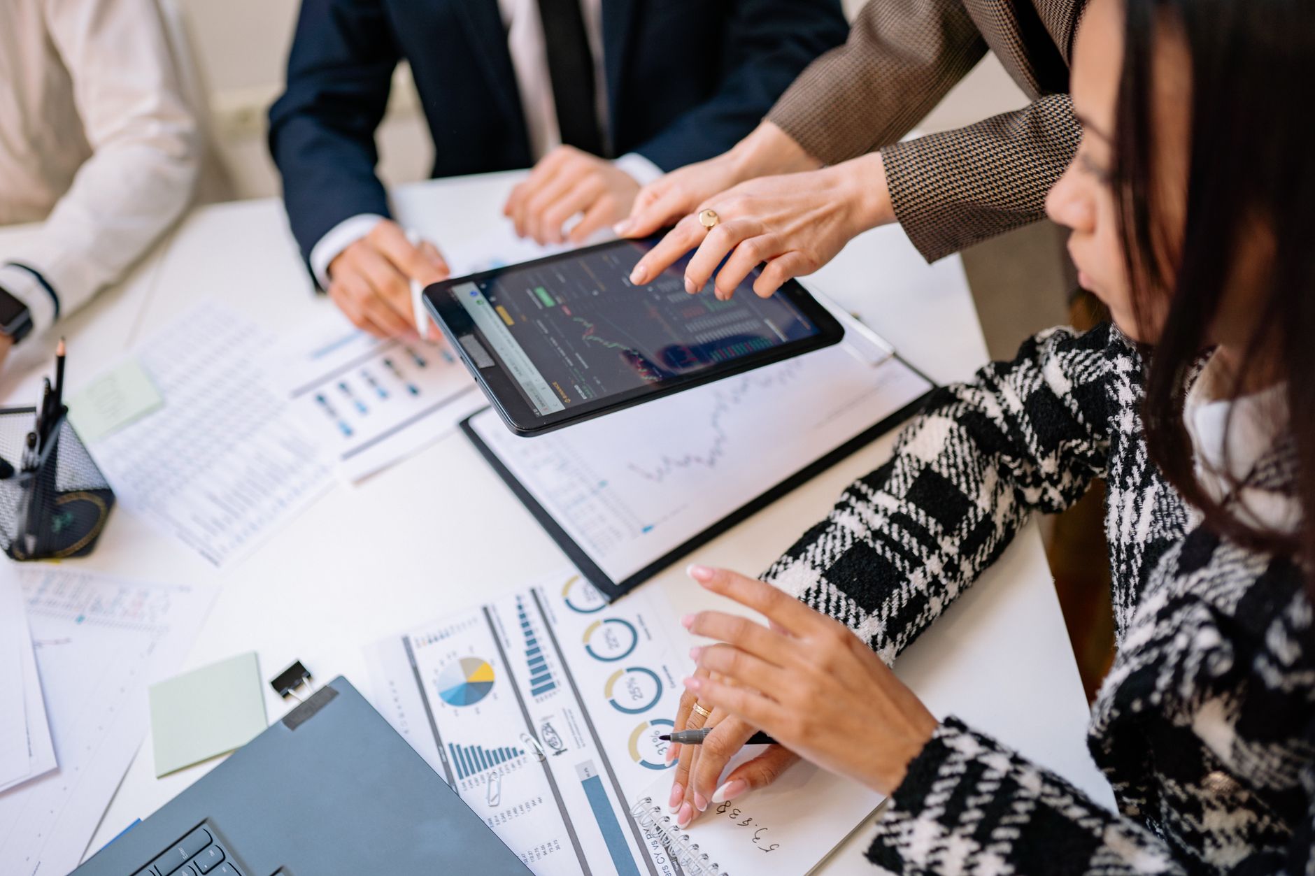 Business professionals reviewing analytics on a tablet during a meeting. — Masters Golf Packages for the Ultimate Fan Experie