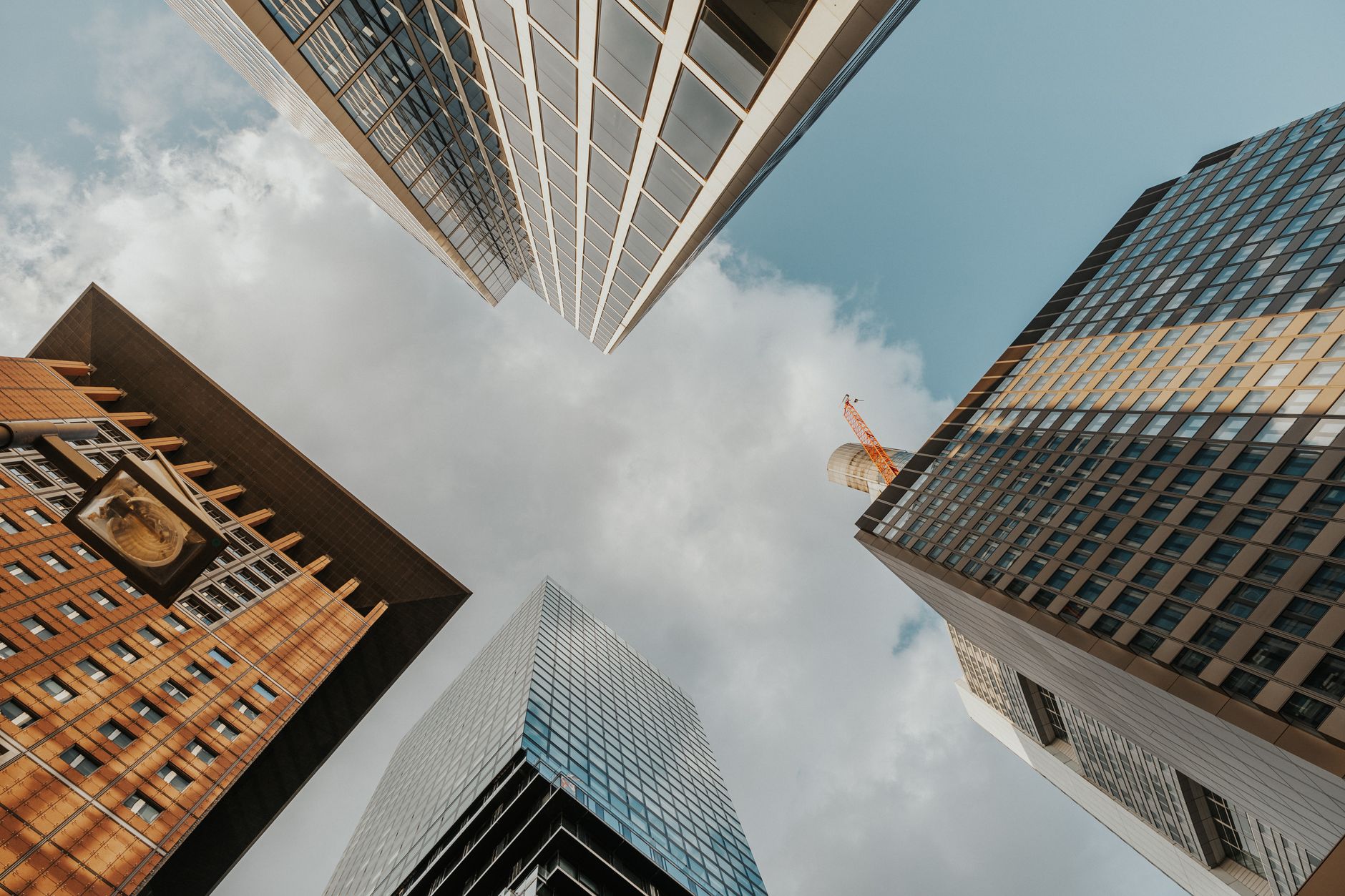 Looking up at diverse modern skyscrapers reaching into a partly cloudy sky. — StreamEast: Navigating the Digital Landscape wi